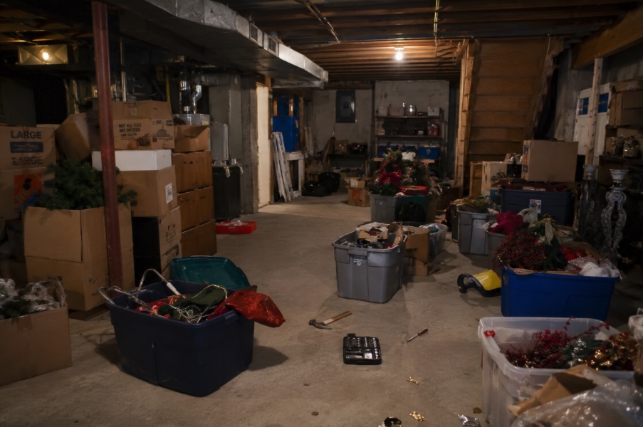Cluttered basement with stacked boxes and disorganized storage before professional organizing in New Jersey